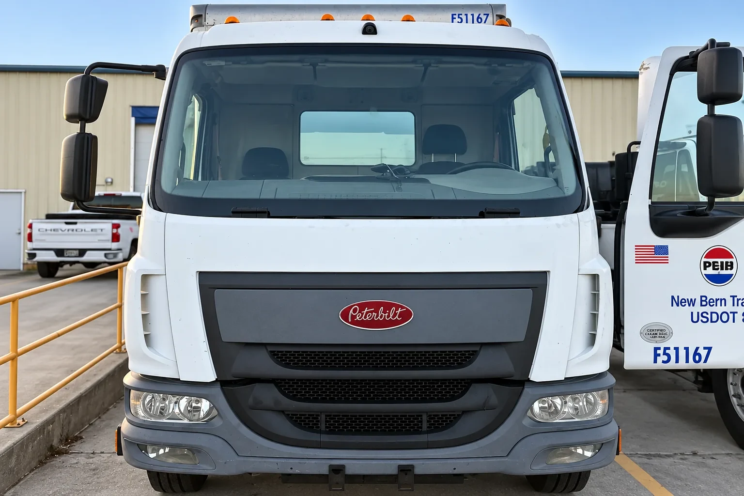 Front view of a white Peterbilt truck with installed windshield.