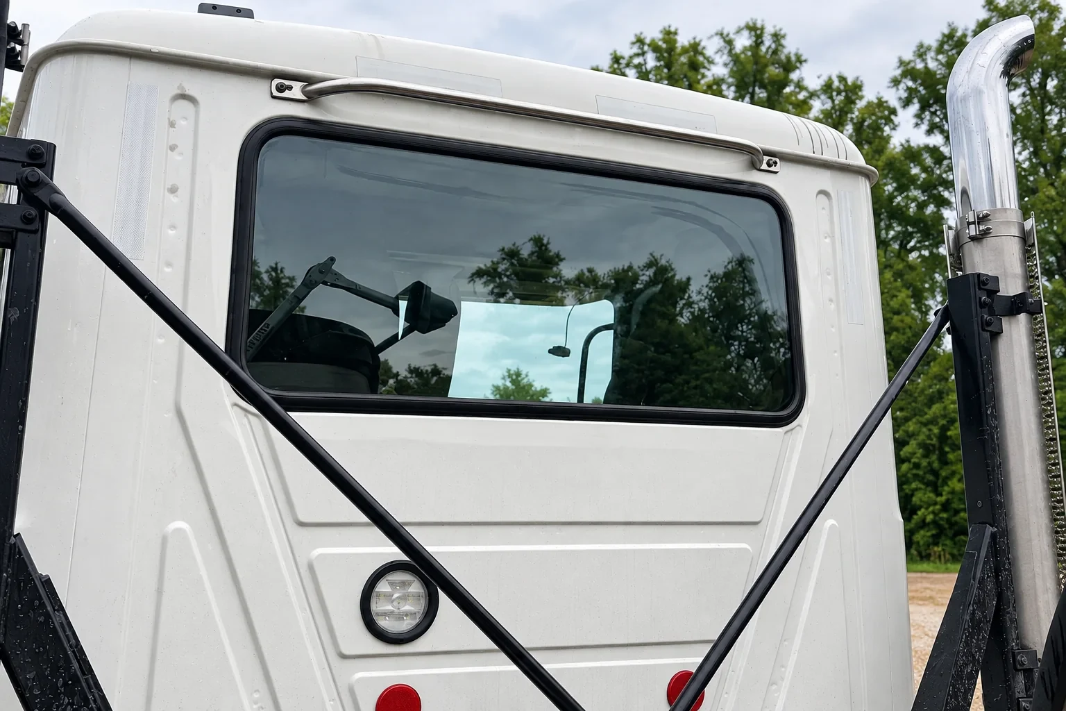 Installed rear cab window on a white commercial truck.